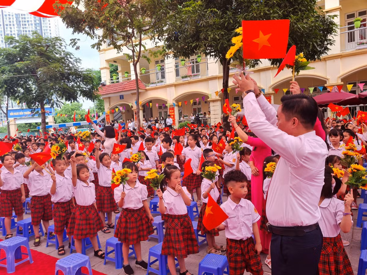 Thầy Trần Văn Hà, Hiệu trưởng Trường Tiểu học Nam Trung Yên vỗ tay đón chào các em lớp 1 trong Lễ khai giảng.
