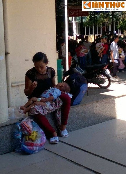 Mẹ con bệnh nhi này kiệt sức vì trời nóng sau gần 2 tiếng chờ đợi nhưng con chị vẫn chưa được khám bệnh.