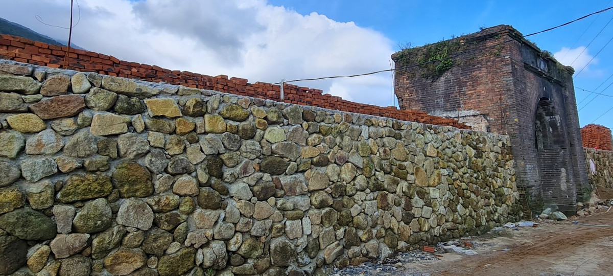 Tường phía trên được xây bằng gạch vồ, phía dưới bằng đá.