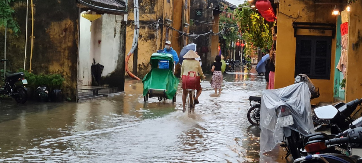 Xích lô, xe đạp, lội bộ giữa dòng nước.