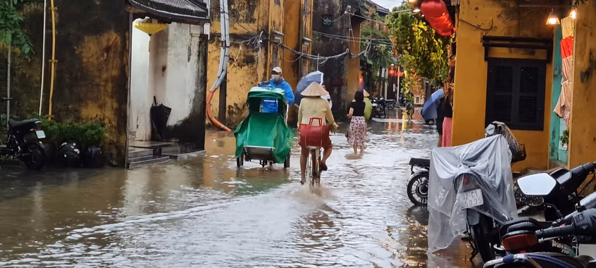 Xích lô, xe đạp, lội bộ giữa dòng nước.