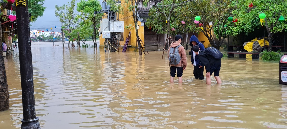 Khu vực ven sông Hoài nước ngập ngang bắp chân. Học sinh tan học phải lội về nhà.