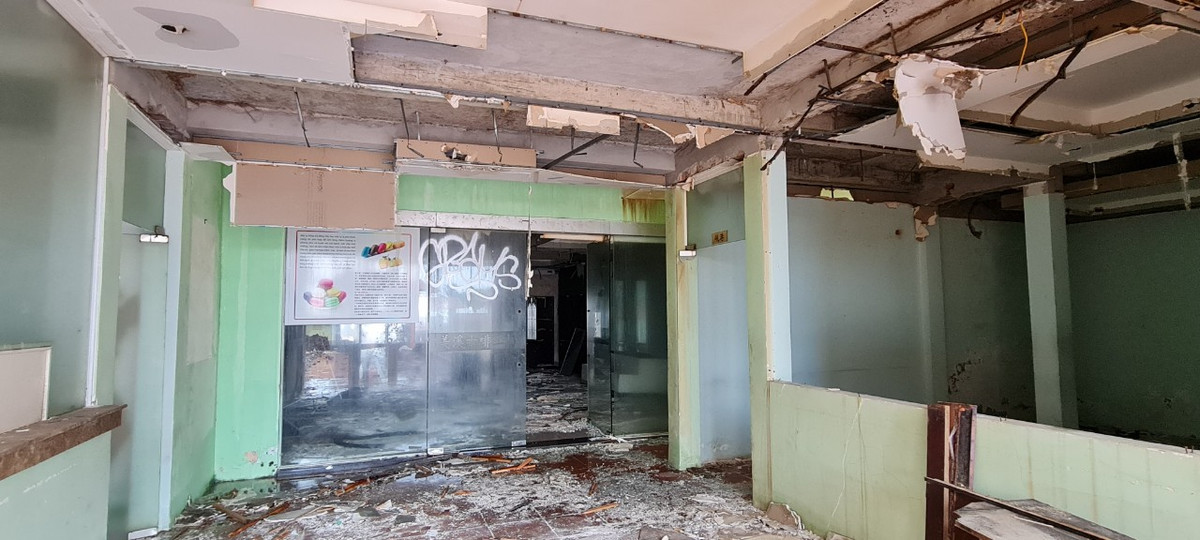 Phía trong công trình là trần thạch cao bị nước thấm rớt xuống từng mảng, rác vây tứ phía tạo điều kiện cho muỗi, ruồi sinh sôi.