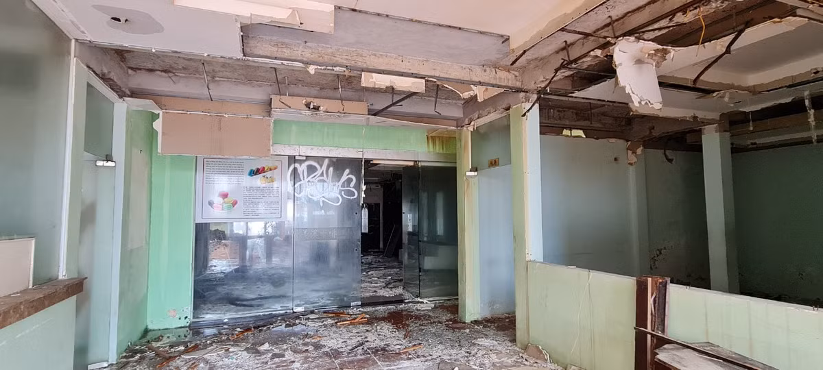 Phía trong công trình là trần thạch cao bị nước thấm rớt xuống từng mảng, rác vây tứ phía tạo điều kiện cho muỗi, ruồi sinh sôi.