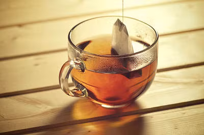 Trà đen cũng rất tốt cho tóc khô và hư tổn vì chứa nhiều polyphenol, vitamin C, E giúp cho tóc mềm và bóng. Trà đen còn bảo vệ tóc khỏi tia UV. Lấy một túi trà đen ngâm với nước nóng. Sau khi gội đầu sạch hết dầu gội, gội lại với nước trà đen rồi để 10-15 phút trước khi xả lại với nước sạch. (Nguồn ảnh: Purewow)