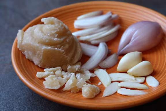 Tỏi, hành khô thái lát mỏng rang khô, ớt rang khô rồi cho vào cối giã cùng với đường thốt nốt rồi xào qua với dầu ăn. 