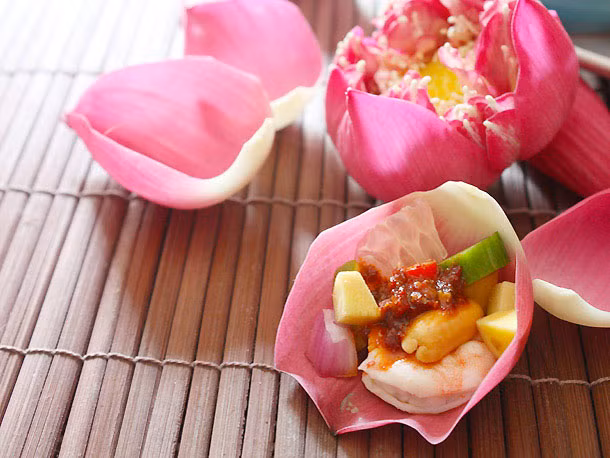 Bày các nguyên liệu nước sốt, tôm, hành, dưa chuột, lạc (hoặc hạt điều), ớt, chanh, bưởi và cánh sen lên đĩa. Món salad tôm này có cách ăn khá đặc biệt: gói mỗi thứ một ít trong lá sen rồi rưới một chút nước sốt lên, cuốn lại và thưởng thức. 