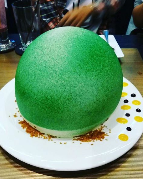 Muốn biết bên trong món ăn xanh mướt có tên “trái đất nóng lên” này là gì thì ngoài đợi 15 phút món ăn mới tới bàn thì khi ăn, bạn phải đợi người ta rưới lên một ít rượu contreau để lớp socola trắng hình cầu kia tan ra và sụp xuống. Thường thì “nội thất” bên trong là sandwich kẹp kem, kẹo dẻo nướng và salad trái cây. (Nguồn ảnh: WOB)