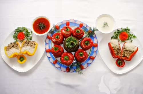 Ớt chuông nhồi thịt lợn: Cho hành tây và tỏi vào chảo sâu lòng. Cho 3 thìa dầu vào chảo, phi thơm. Cho thịt xay vào chảo đảo đều và dầm cho thịt tơi ra. Gạt thịt sang một bên chảo. Cho nấm vào đảo đều. Tắt bếp. Cho hành lá, thì là cắt nhỏ vào chảo. Nêm gia vị, muối, hạt tiêu cho vừa khẩu vị,đảo đều, đổ ra bát. Tiếp đó hồi nhân vào quả ớt. Nhồi một nửa quả ớt với cơm, rồi nhồi tiếp nhân thịt lên trên. Hoặc nhồi một nửa quả ớt với nhân thịt rồi nhồi tiếp với cơm, cho vào lò nướng khoảng 40 phút là được. 