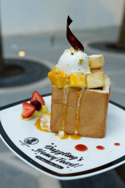 Bánh mì nướng mật ong trông khá bắt mắt bởi chiều dày ấn tượng của khoanh bánh mì, bên trên có kem tươi và kem lạnh. 