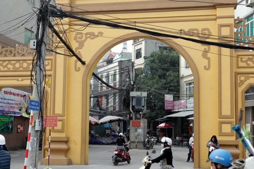 Một búi dây cáp điện, viễn thông xuyên tường cổng làng Cốm Làng Vòng (quận Cầu Giấy) nối với trạm biến áp.