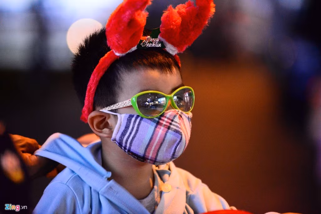 Trẻ em diện đồ Giáng sinh đi chơi tối cùng cha mẹ. 