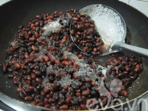 Sau khi hạt đỗ đã chín mềm, dùng muôi có lỗ vớt hết đỗ ra một cái nồi khác và để lại nước đỗ đen trong nồi. Cho đường vào sên cùng với hạt đỗ và đun trên lửa nhỏ cho đến khi đường tan hết ngấm vào hạt đỗ. Nếm đỗ ngọt đậm thì tắt bếp. Ảnh: Eva