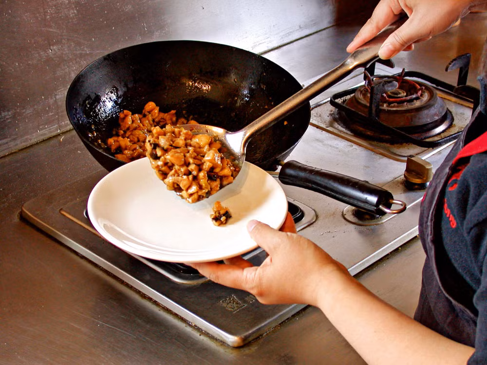 Cuối cùng cho thêm một ít dầu mè vào đảo đều rồi trút thịt gà ra đĩa.