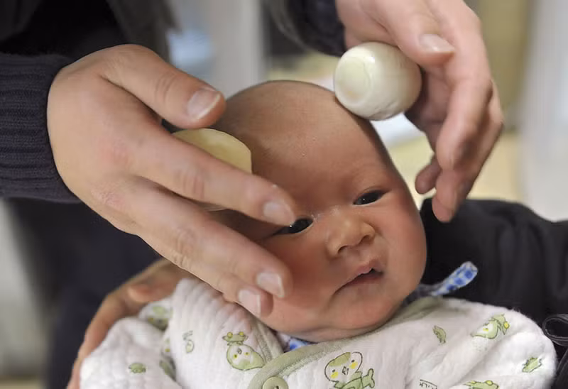 Các ông bố Trung Quốc thường hay trẻ sơn sinh đi mát-xa đầu bằng trứng luộc để thư giãn và lấy may.