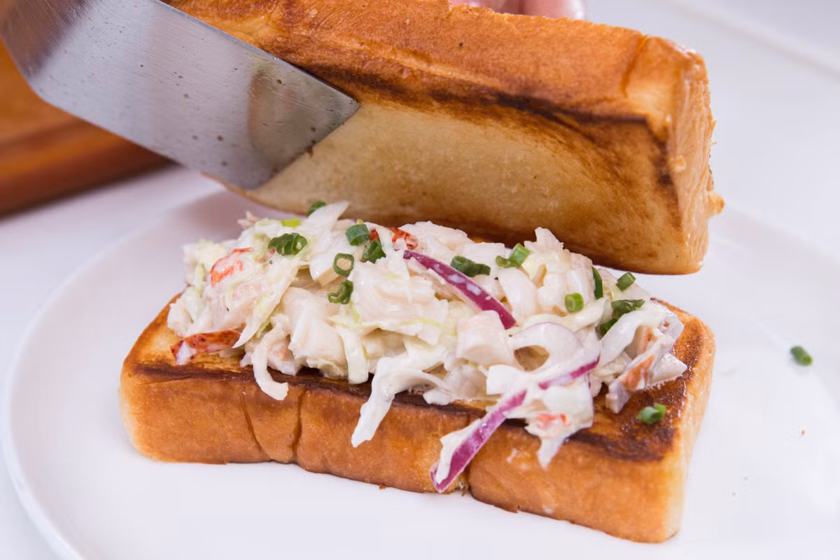 Lấy 2 lát bánh mì kẹp salad tôm vào giữa, nếu ăn được tỏi sống thì rắc thêm một ít tỏi cho thơm. (Nguồn ảnh: Daycook)