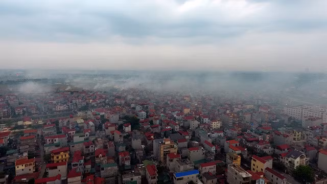 Khói đốt rơm rạ, cây cỏ phủ khắp một khu dân cư gần hồ Tây.