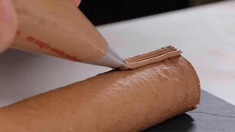 Số kem tươi còn lại dùng dụng cụ bắt kem để phết lên bánh.