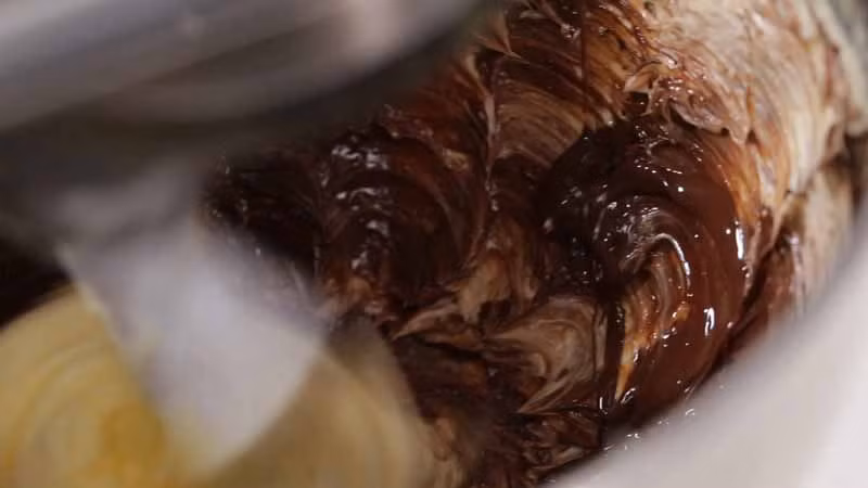 Từ từ cho socola đã làm tan vào hỗn hợp kem và trộn đều.