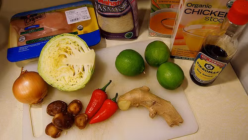 Nguyên liệu cho món canh gạo nấu chua cay độc đáo gồm có: 1 thìa dầu hạt cải, 1 củ hành tây, 200g nấm đông cô thái lát, 1-3 quả ớt thái nhỏ, 6 nhánh tỏi băm nhỏ, 1 nhánh gừng băm nhỏ, 3 quả chanh, nước dùng gà, 2 miếng ức gà không xương bỏ da, ½ chén gạo, ½ cây bắp cảo thái sợi nhỏ. 2 thìa nước tương. 