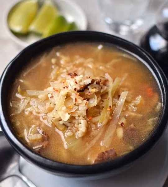 Trong lúc chờ đợi canh gạo chín thì dùng tay xé nhỏ thịt gà ra. Khi hạt gạo đã mềm, cho thịt gà xé vào nồi cùng với bắp cải, nước chanh và nước tương, nấu thêm khoảng vài phút nữa hoặc cho đến khi bắp cải nóng và mềm là được.