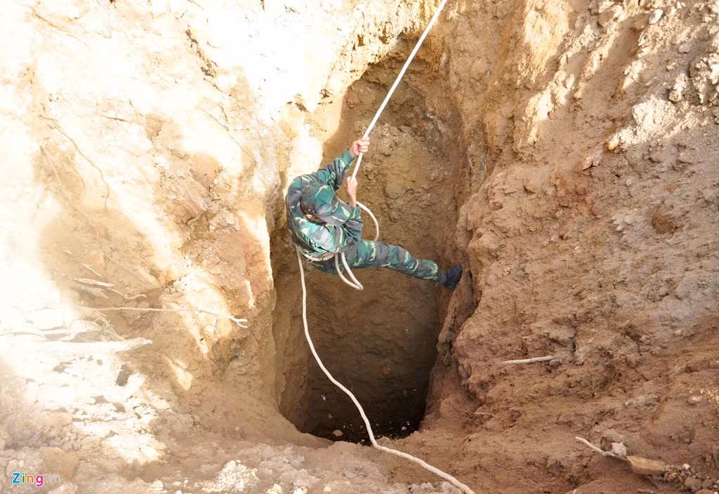 Chiến sĩ công binh đu dây xuống hầm khai thác vàng sâu hơn 10 m cài đặt thuốc nổ. 