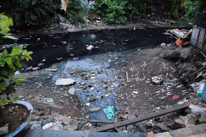 Trong khi chờ di dời thì người dân vẫn phải sống chung với cảnh ô nhiễm.