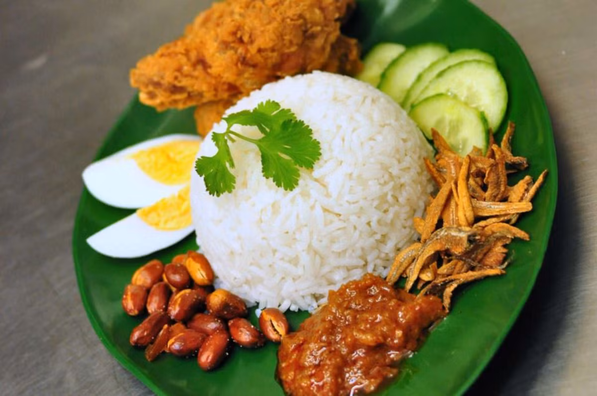 Quốc khánh Malaysia được kỷ niệm bằng món nasi lemak, một món cơm dễ gây nghiện gồm có cơm nấu nước cốt dừa, lá dứa, gừng, xả và đậu phộng chiên giòn.