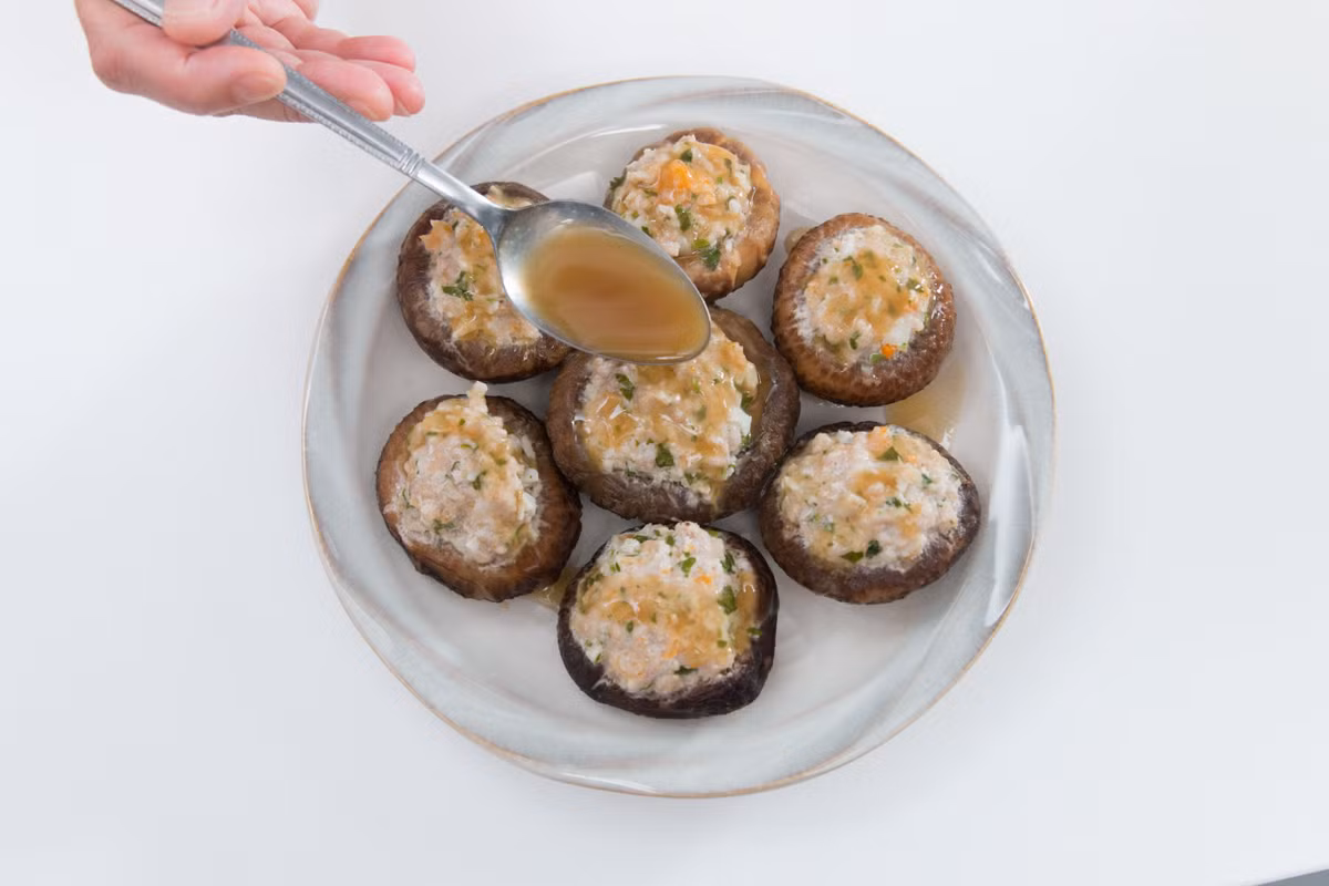 Dùng nước này rưới đều lên trên nấm nhồi thịt đã hấp rồi rắc thêm một chút hành mùi lên trên. 