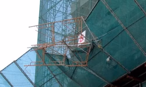 Đoạn giàn giáo bị rơi treo lơ lửng trên đường Trần Phú, đoạn gần đối diện cổng resort Ana Mandara.