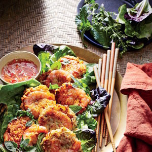 Bánh tôm khoai lang ăn kèm với nước mắm và các loại rau sống như xà lách, rau mùi, rau bạc hà.