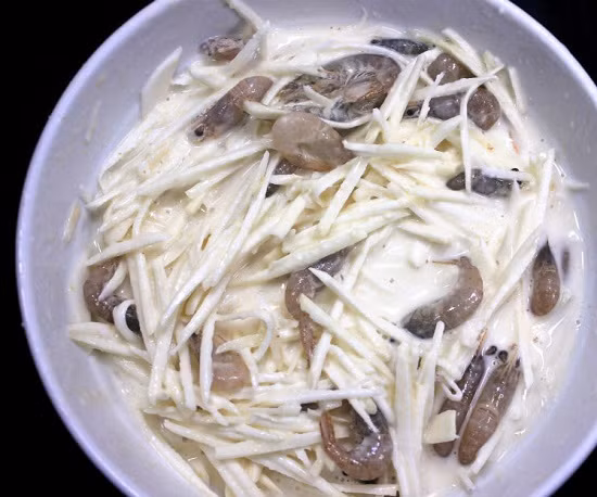 Tiếp đó cho khoai lang vào bột và đảo đều. 