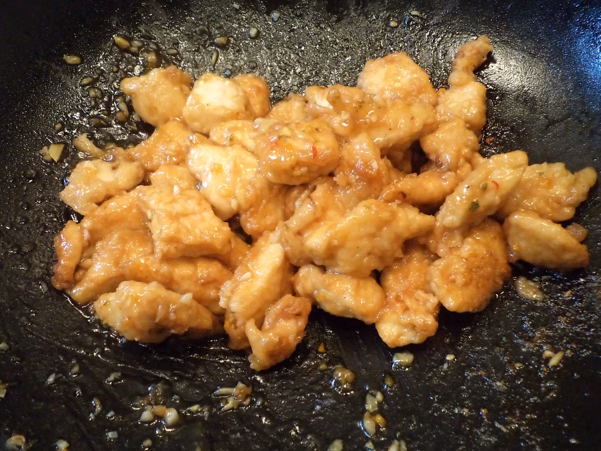 Cho 2 thìa dầu ăn vào chảo, bật lửa to, khi dầu bốc khói thì cho gà vào dàn đều trên mặt chảo. Rắc một chút muối và hạt tiêu vào cho vừa ăn. 