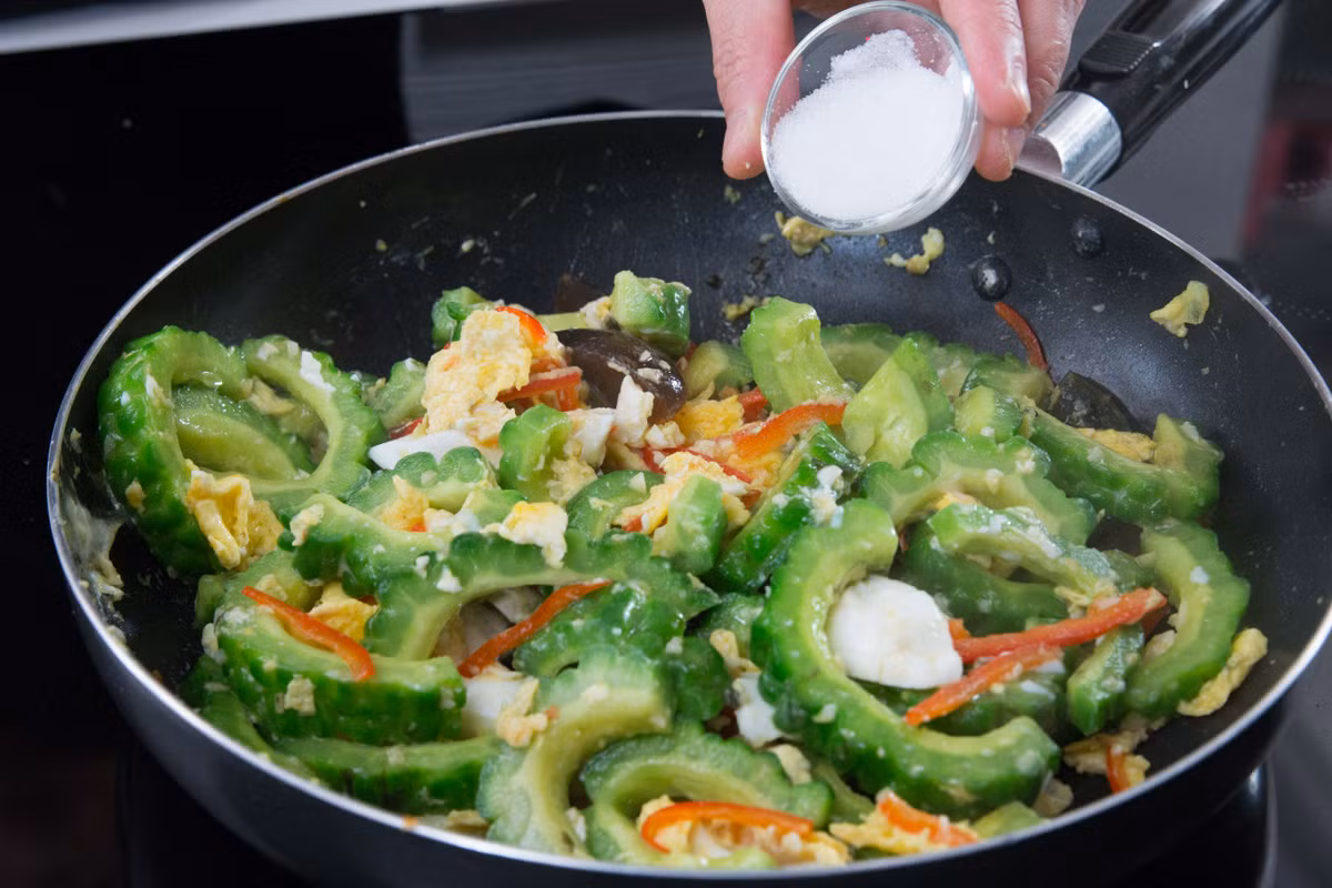 Đảo đều cho đến khi trứng dính đều lên mướp đắng thì nêm nếm gia vị cho vừa ăn. 