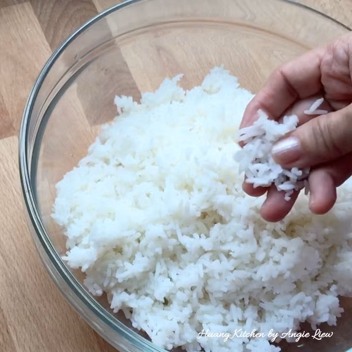 Để làm món cơm chiên Malay cho khoảng 2 người ăn, lấy 3 chén cơm nguội, tốt nhất là chọn cơm nấu từ gạo ít dính, cho vào bát to. Nhúng tay ướt rồi bóp đều cơm sao cho các hạt cơm tơi ra, không dính cục.