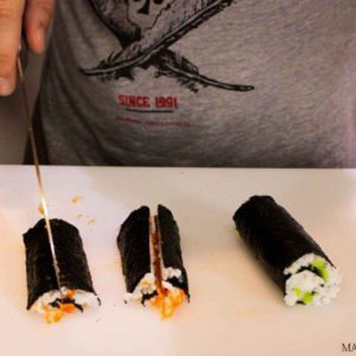 Khéo léo dùng dao cắt cuộn sushi thành 4 phần theo chiều dọc.