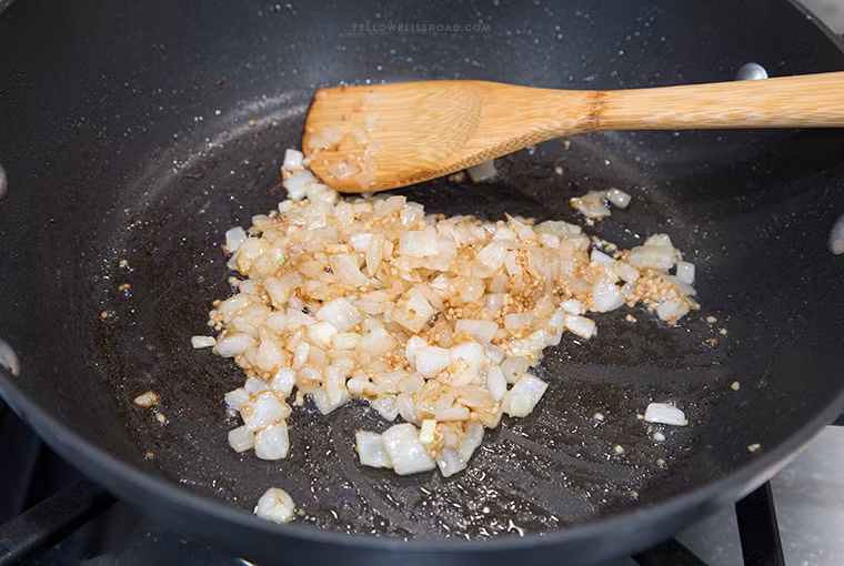 Phi thơm tỏi, cho hành tây vào xào khoảng 1 phút đến khi hành mềm và trong.