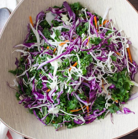 Trộn đều rau bắp cải tím, bắp cải trắng, cà rốt, cải xoăn trong 1 bát to rồi để sang một bên. Trộn đều tất cả các nguyên liệu làm nước sốt salad vào trong bát rồi rưới dần từng thìa vào phần rau. Chỉ nên dùng vừa đủ để nước sốt phủ lên bề mặt rau củ. Phần nước sốt còn lại để dùng vào việc khác. 