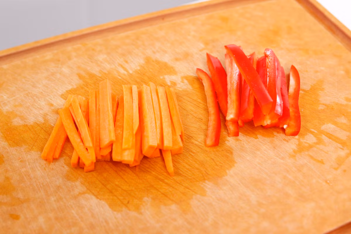 Cà rốt và ớt chuông thái thành miếng dài bằng với chiều dài của đậu Hà Lan. 