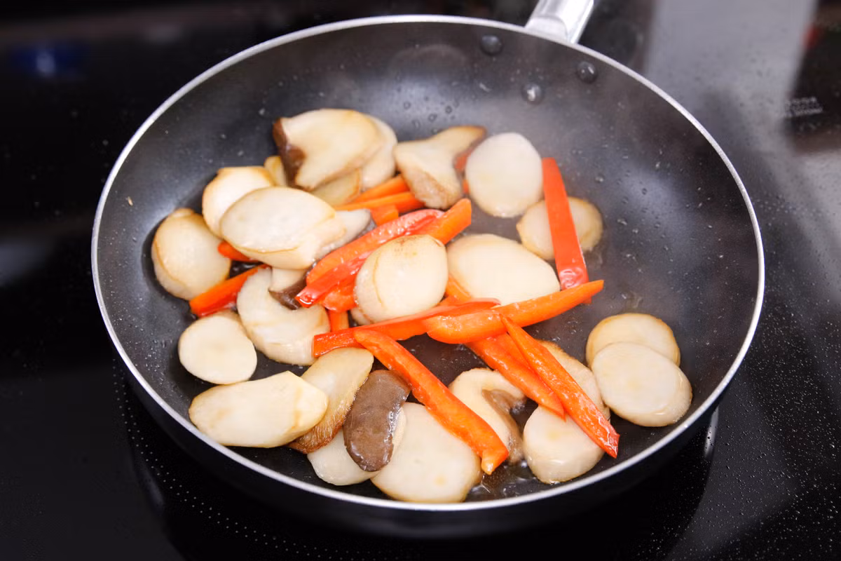 Cho một ít dầu vào chảo rồi cho nấm và ớt chuông vào đảo qua đến khi chuyển màu vàng. 