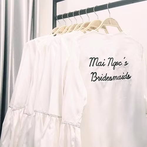 Dàn phù dâu còn có riêng áo choàng bằng satin thêu chữ Mai Ngoc's Bridesmaids(Phù dâu của Mai Ngọc) sau lưng. 