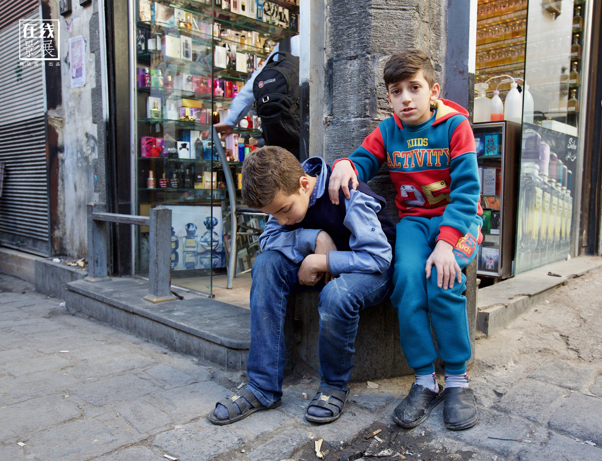 Hai bé trai ngồi ở góc đường ở Thủ đô Damascus.