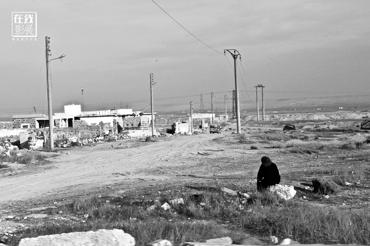 Người phụ nữ ngồi bên đường hoang vắng. Đây là hình ảnh tuyến đường chạy từ Damascus tới Aleppo.