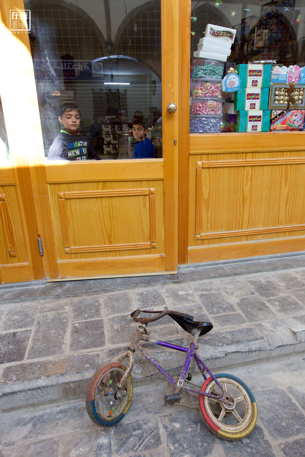 Hai em bé đứng trong một cửa hàng bán kẹo ở Homs.