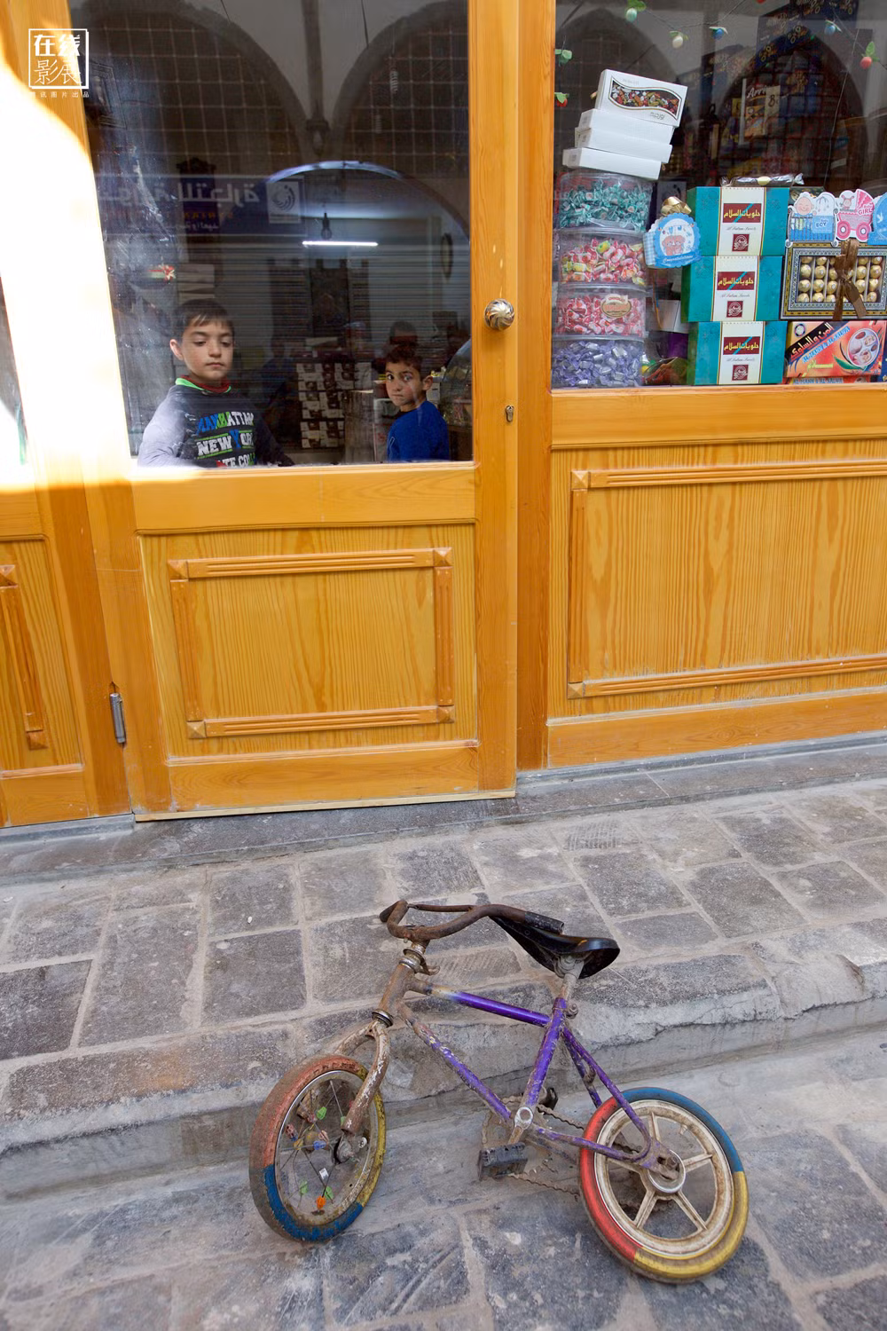 Hai em bé đứng trong một cửa hàng bán kẹo ở Homs.