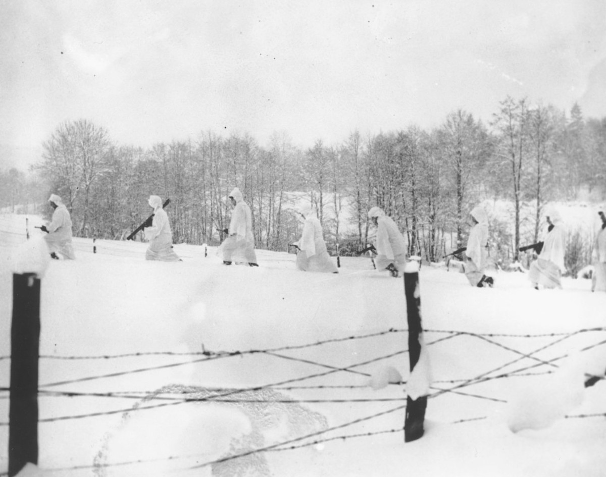 Những tấm dù mang theo hàng tiếp tế sau đó cũng trở thành trang phục nguỵ trang thích hợp cho binh lính Mỹ trên chiến trường đầy tuyết trắng này. Nguồn ảnh: BI.