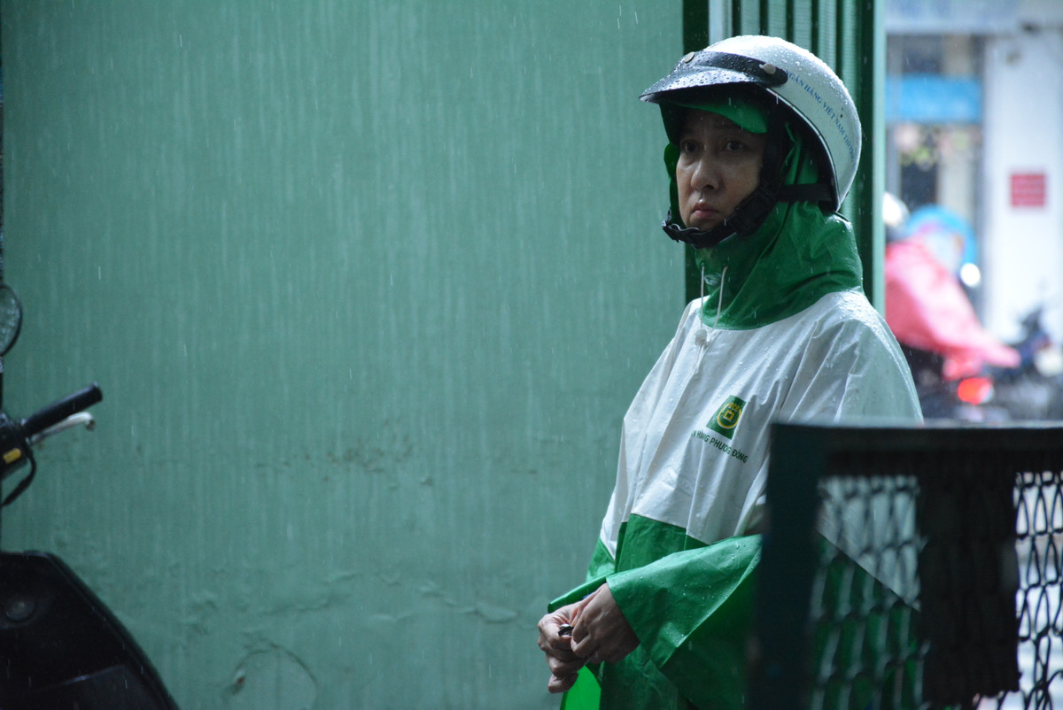 Trong buổi chiều thi môn ngoại ngữ, TP HCM có mưa lớn, phụ huynh không ngại đội mưa đứng chờ con thi tại điểm thi THPT Nguyễn Khuyến (quận 10)