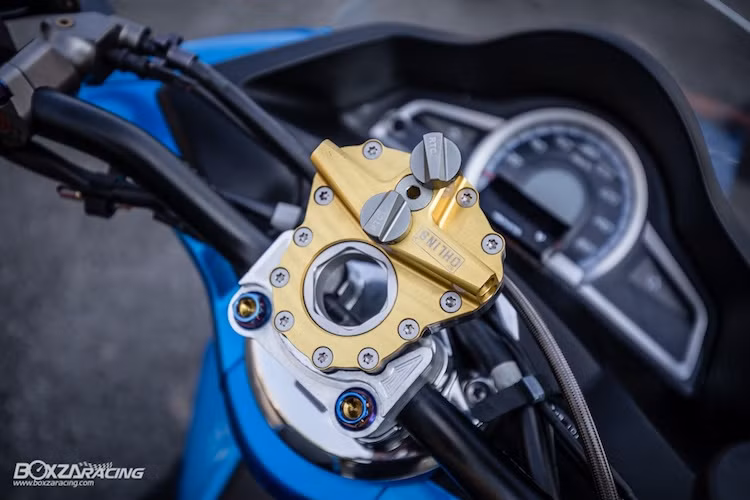 Nằm ở phía trên tay lái, chiếc PCX đã được thay ghi-đông nguyên bản bằng tay lái Rizoma với chiều cao thấp nhưng rộng hơn. Ở trên ghi-đông là bộ trợ lực tay lái Ohlins, trong khi bảng đồng hồ của chiếc xe được trang bị thêm một đồng hồ Koso Mini 3 nhỏ, chỉ báo thêm thông số điện bình.