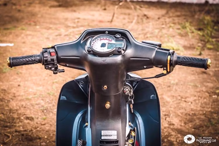 Nằm ở phía trên tay lái của chiếc xe, cụm đồng hồ điện tử Koso RX2N đã được chế mủ vừa khít với phần đầu của chiếc Wave. Trong khi đó, cùm ga của xe cũng được nâng cấp bằng cùm Red Leo. Bên dưới yếm phải còn có sự xuất hiện của cây trợ lực Apido để giữ đầu xe ổn định ở tốc độ cao.