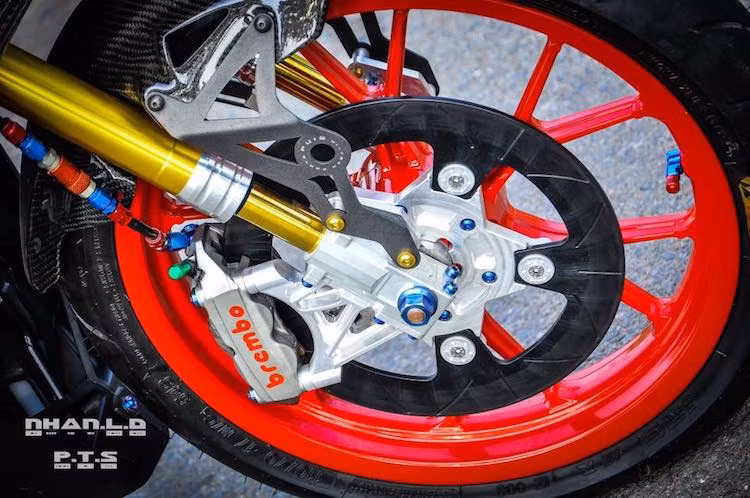 Trên chiếc xe này, cặp mâm trước sau của Exciter nguyên bản đã được thay bằng mâm 6 cánh chữ Y có nguồn gốc từ mẫu sportbike 2 kỳ Aprilia RS50. Ngoài ra, "dàn chân" trước cũng trở nên nổi bật với phuộc Gazi tiện chân nhôm CNC phong cách phuộc Ohlins, đĩa phanh Carbon Black và heo Brembo M4 4 piston.